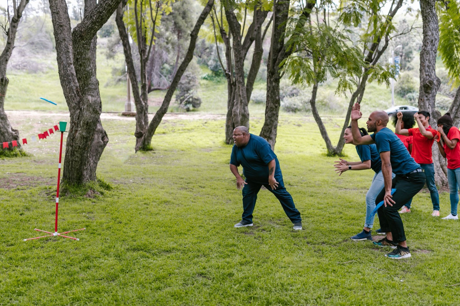 Colleagues throwing at a target station on grass, one of them mid-throw.