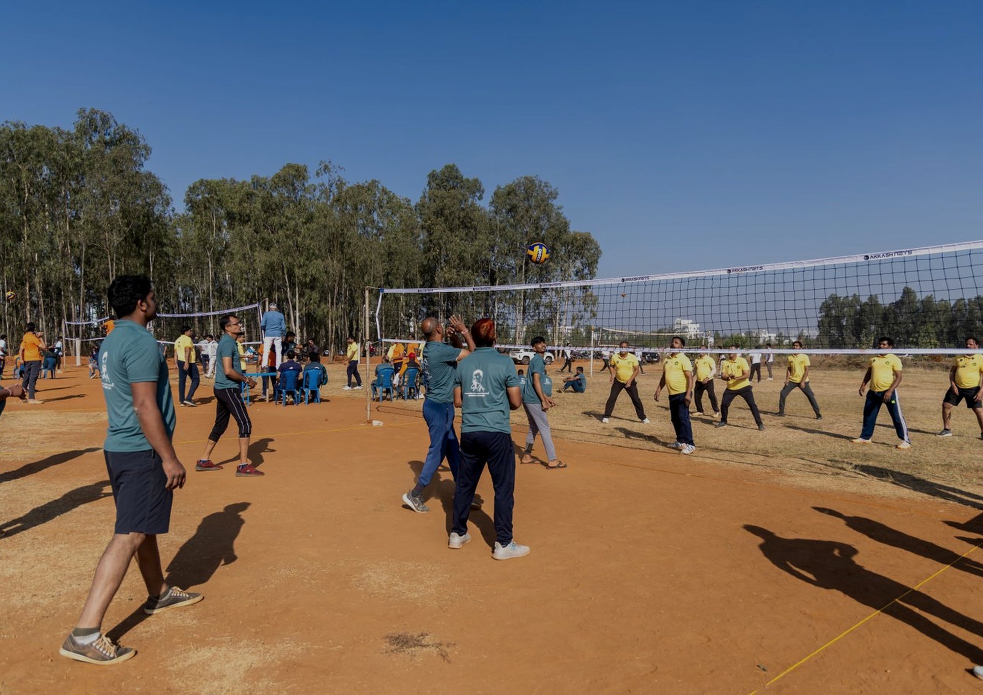 Two volleyball courts running at once at a corporate sports day.